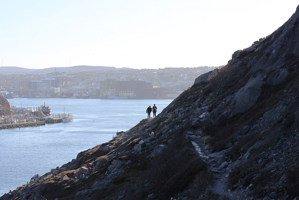 Two people hiking on a steep slope.