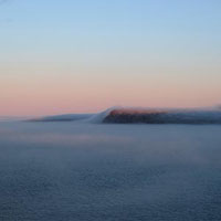 Fog billowing upwards onto the hills near Cape Spear.