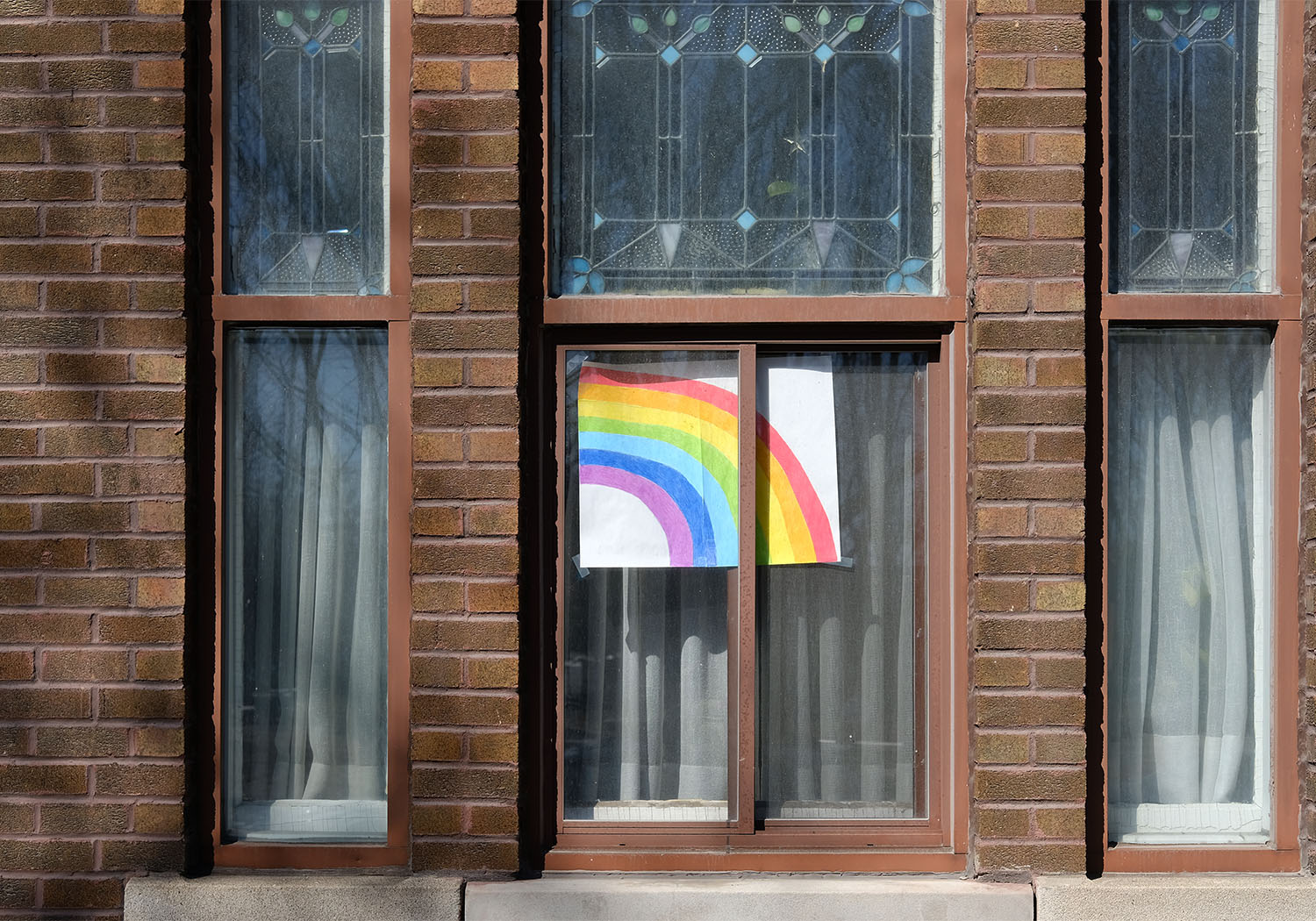 A hand-drawn rainbow in a window.